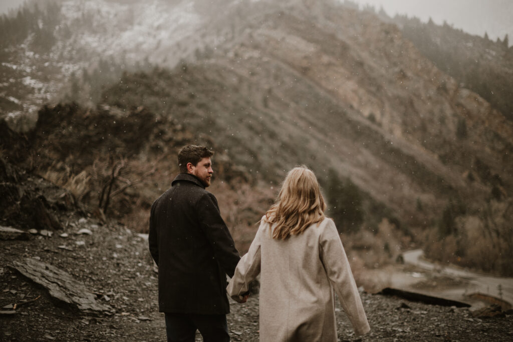 Engagement session with a cute couple walking around in the mountains with a light snow fall.