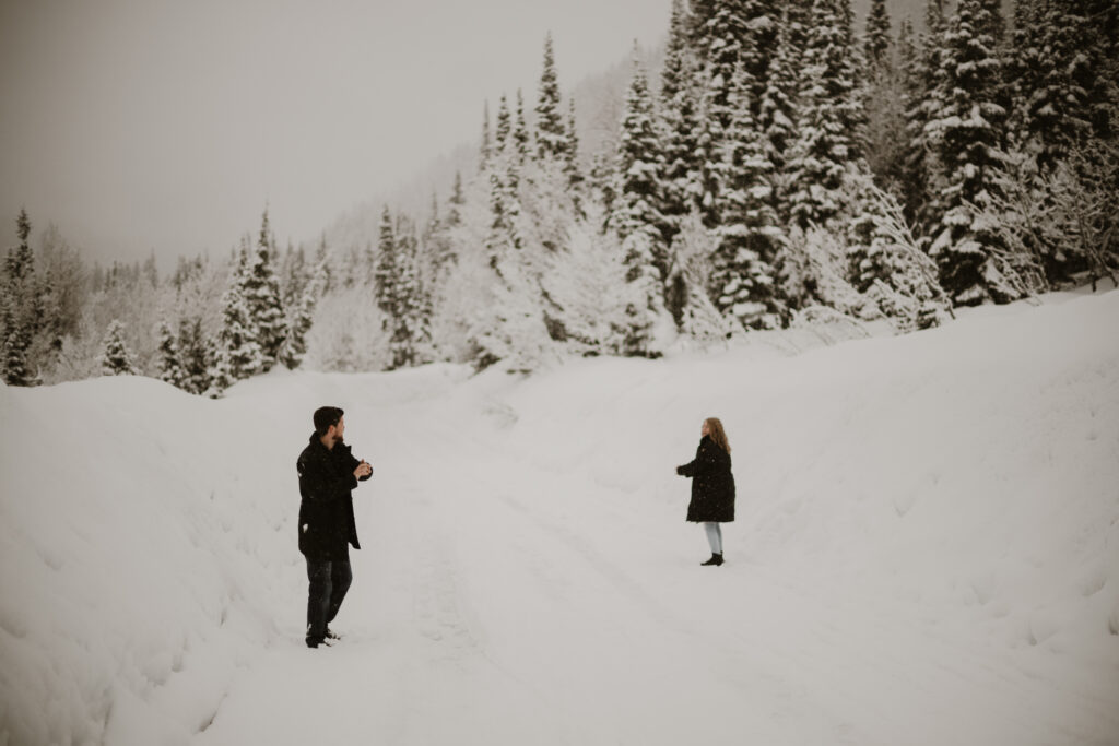 Couple having a snow ball fight in the mountains in the winter