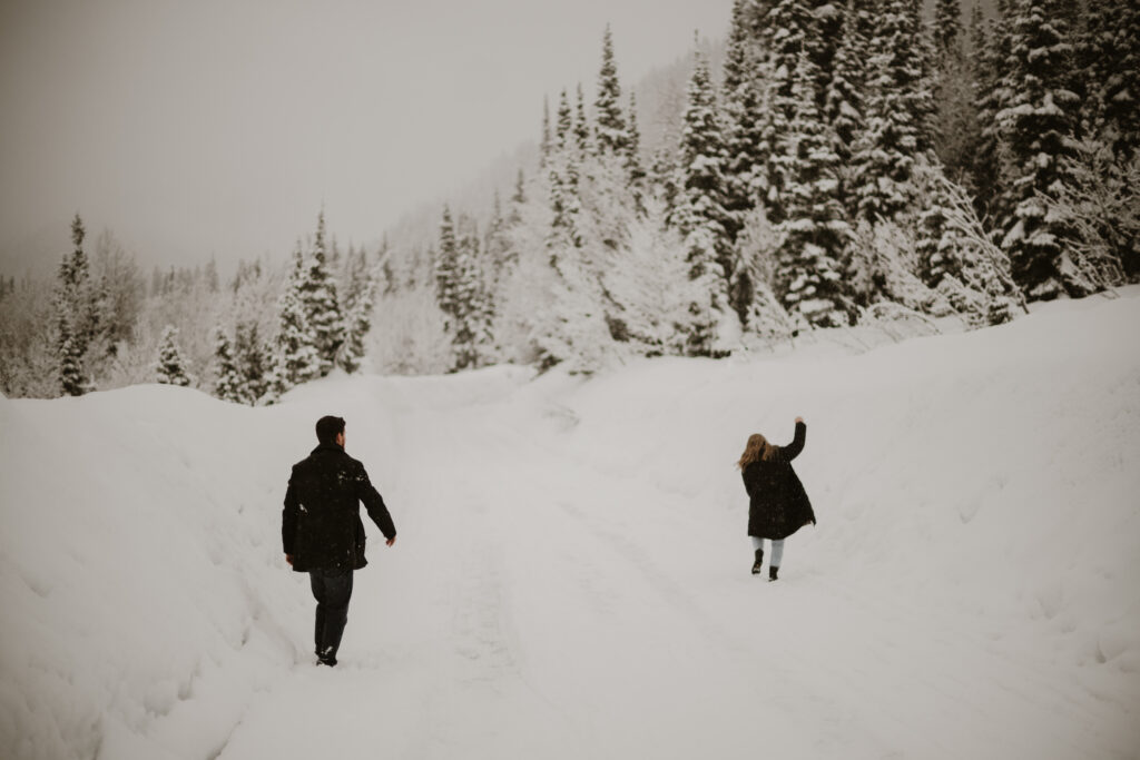 Couple having a snow ball fight in the mountains in the winter