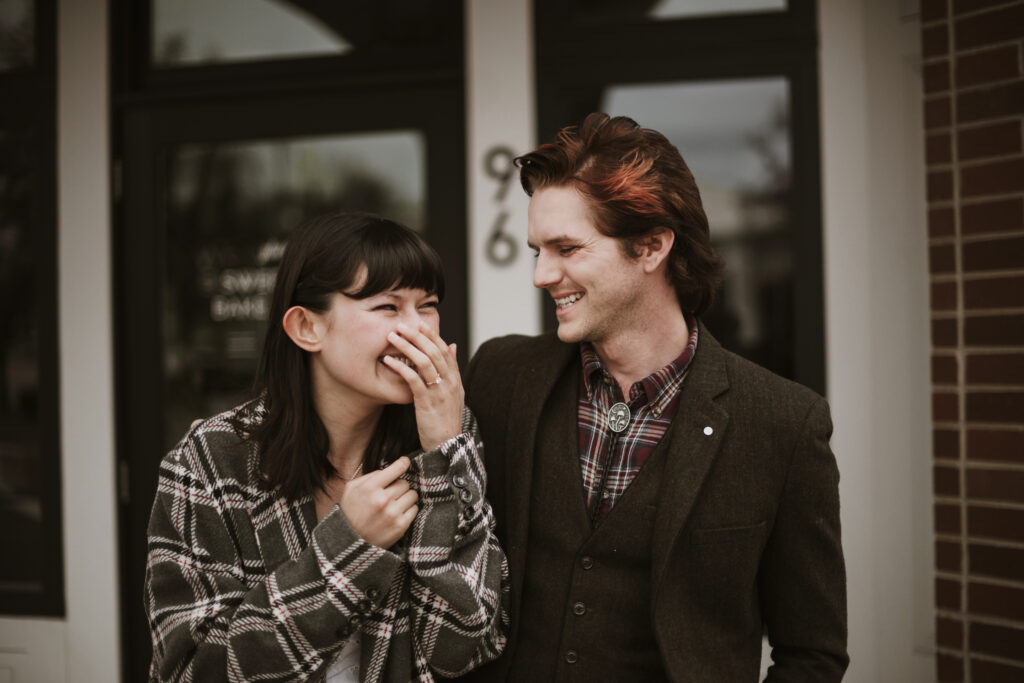 Cute couple laughing who just got engaged after a surprise proposal.