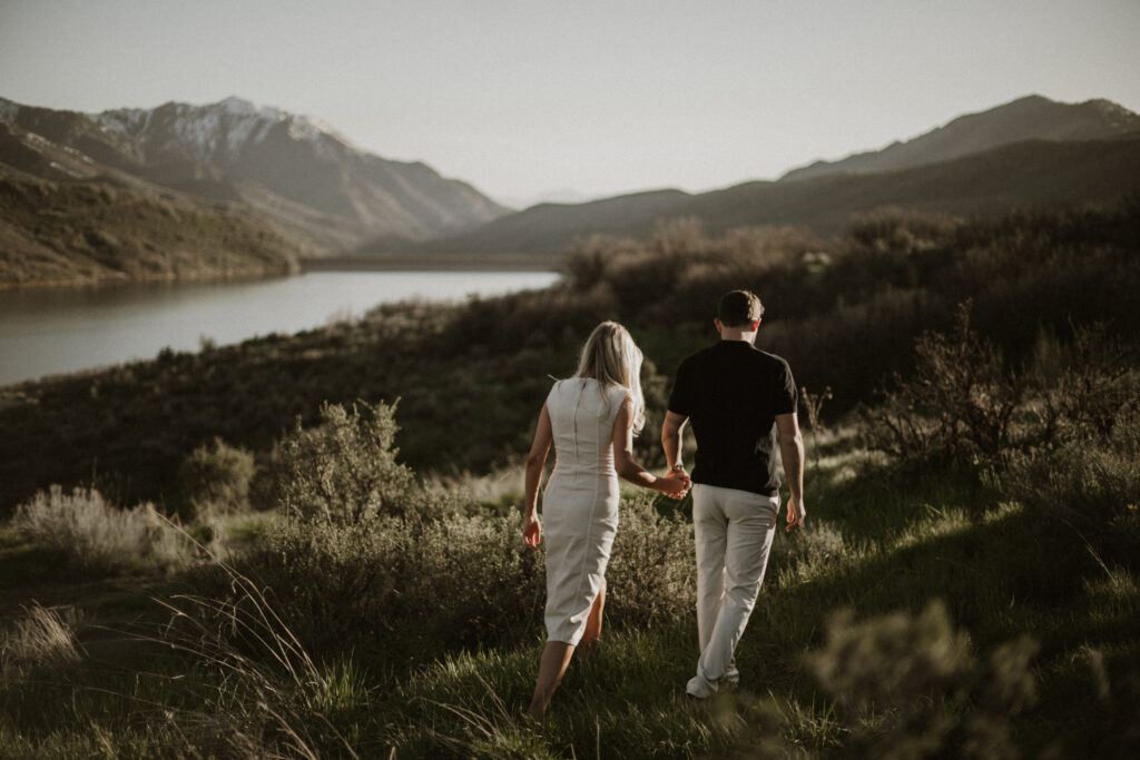 Couple holding hands walking in a field