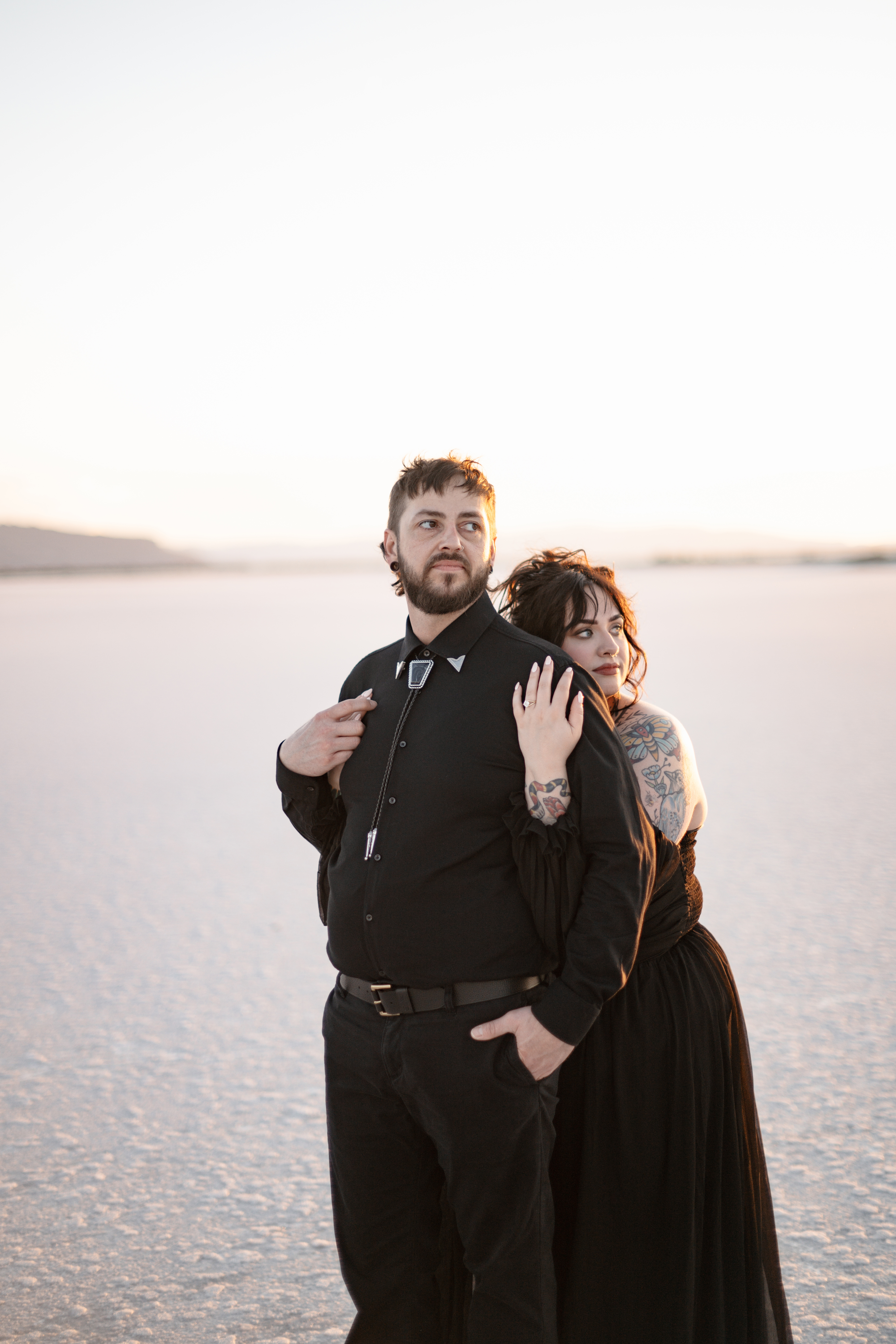 Engagement photos at the Bonneville Salt Flats in Utah with a couple wearing all black outfits