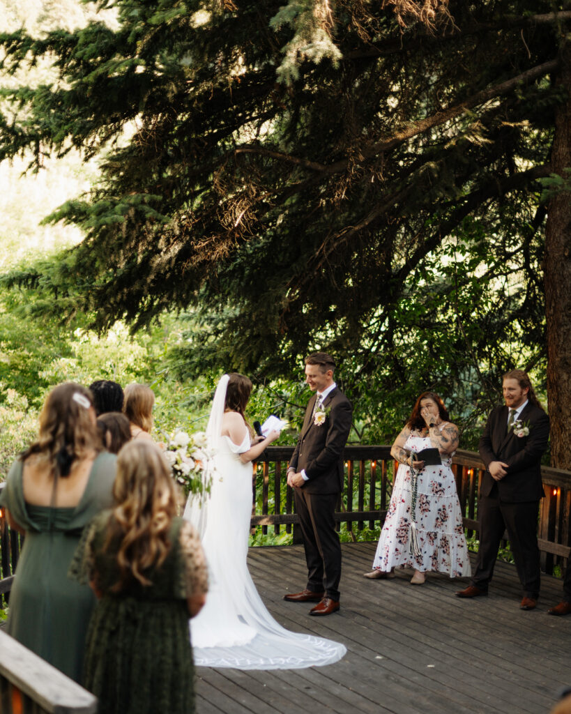 Bride and groom reading vows in the trees during their wedding ceremony in Utah.