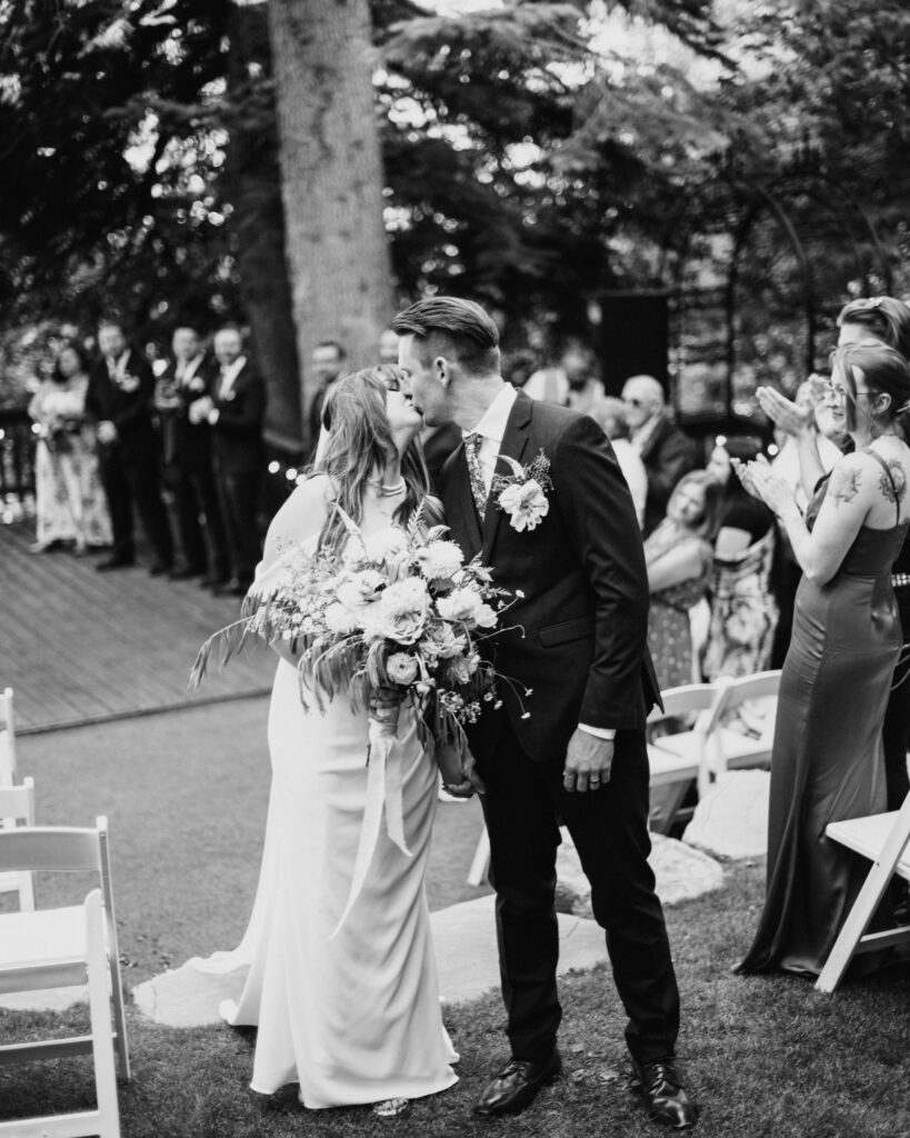 Bride and groom kiss walking back down the aisle