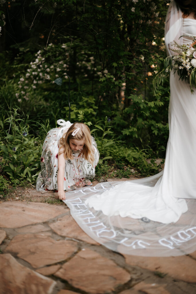 Flower girl fixing the brides veil
