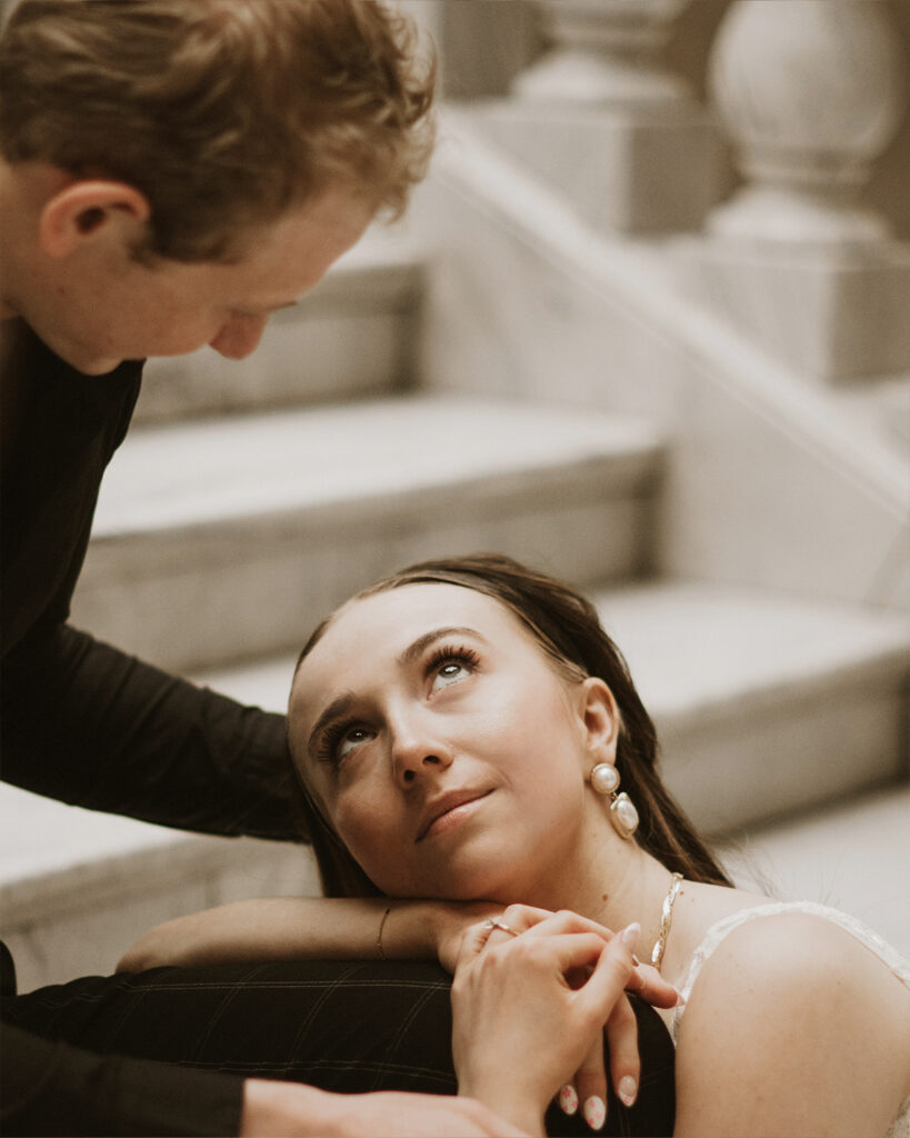 Bride looking up at groom in cinematic lighting.
