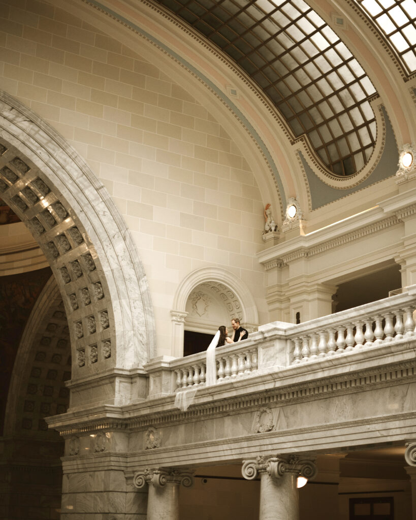 How to get married at the Utah State Capitol Building. Bride and Groom with veil hanging over railing. 