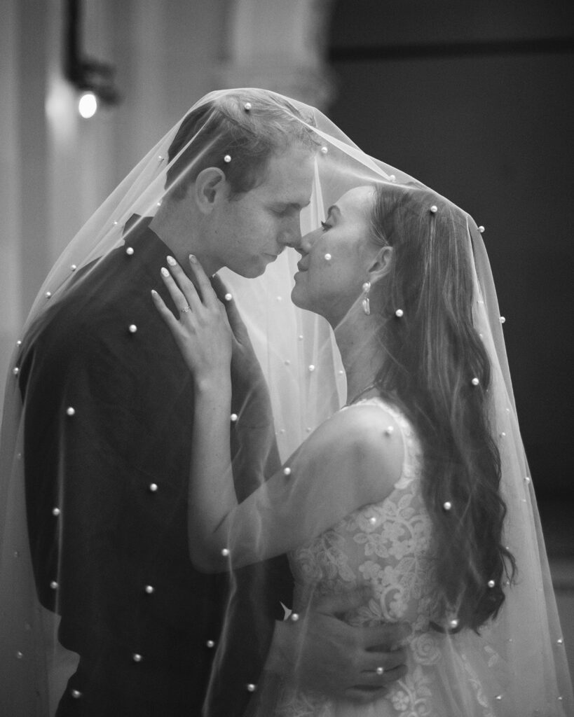 Bride and Groom under pearl veil.