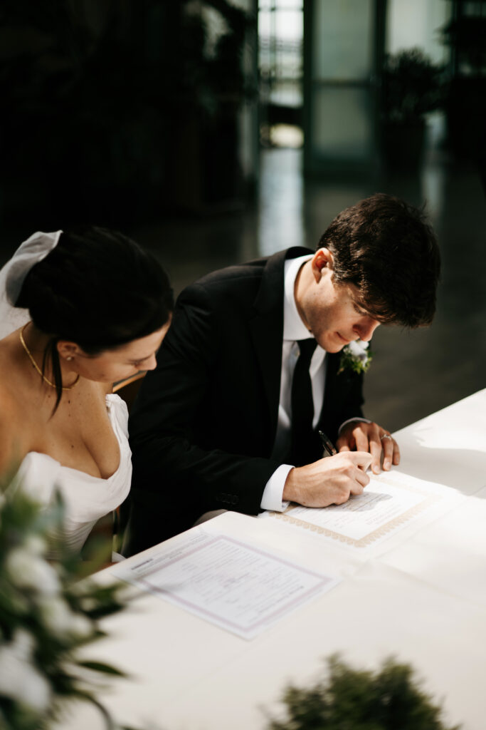 Bride and groom signing marriage certificate