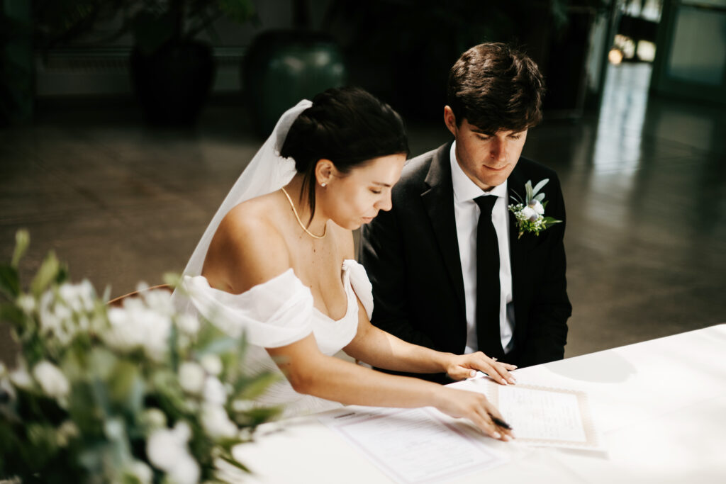 Bride and groom signing marriage certificate