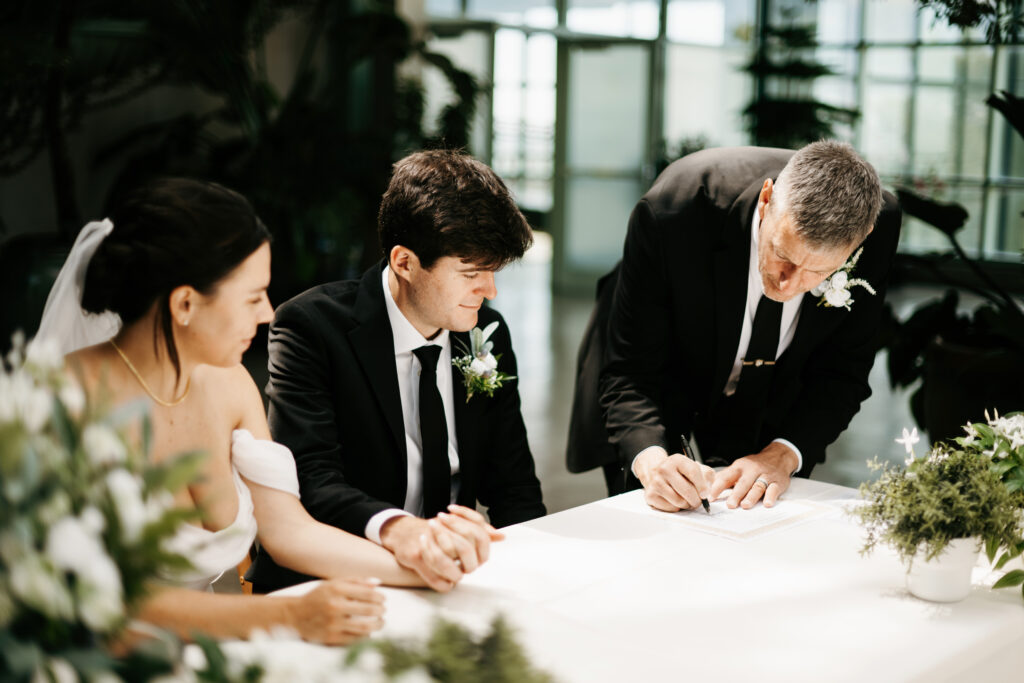 Bride and groom signing marriage certificate