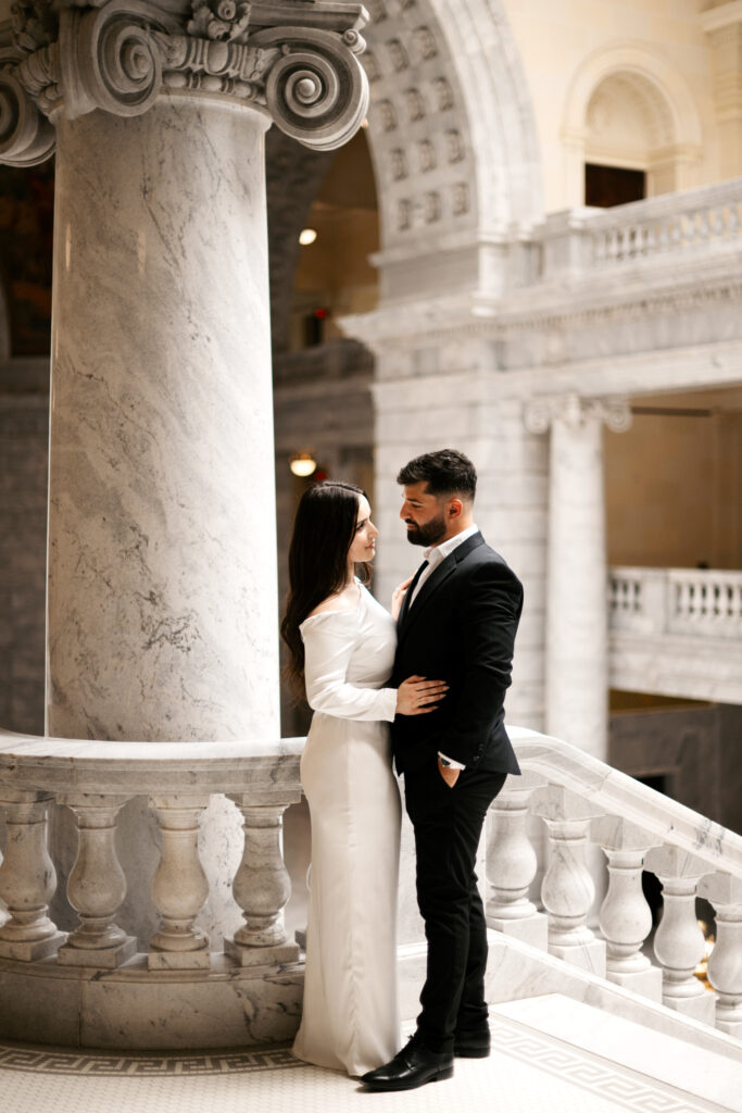 Engagement photos at the Utah state capitol building with girl in a white dress and man in a black suit
