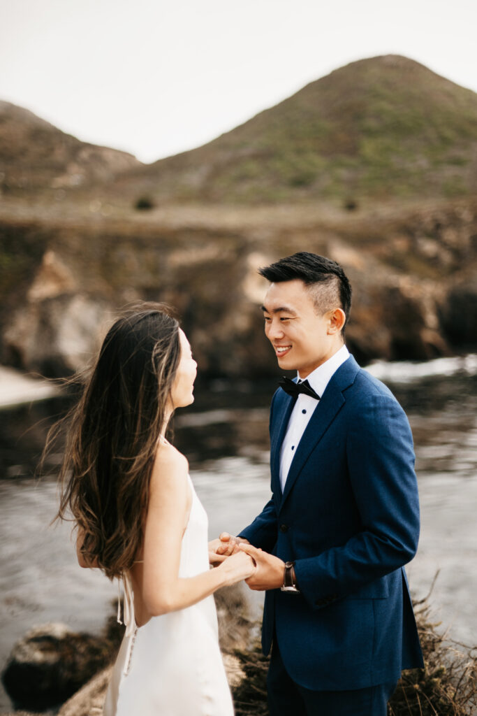 Bride and groom exchanging vows on a cliffside in Big Sur, California.