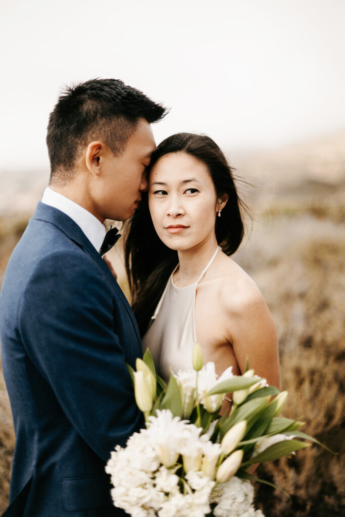 Bride and groom exchanging vows on a cliffside in Big Sur, California.
