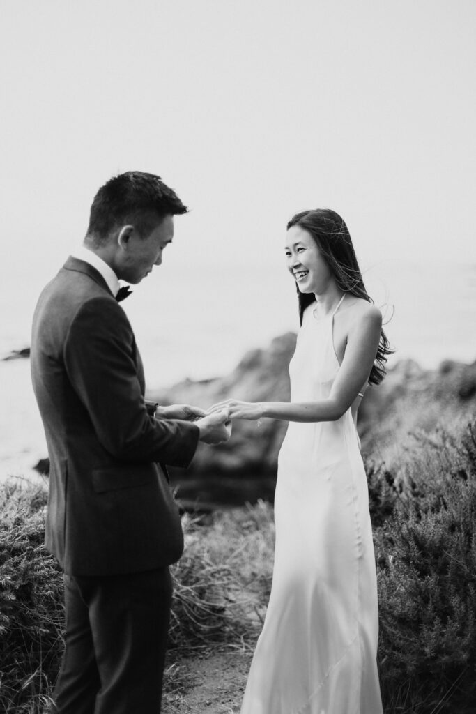 Bride and groom eloping in California on a cliffside in a navy suit and white silk wedding dress.