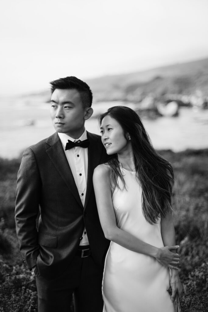 Bride and groom eloping in California on a cliffside in a navy suit and white silk wedding dress.