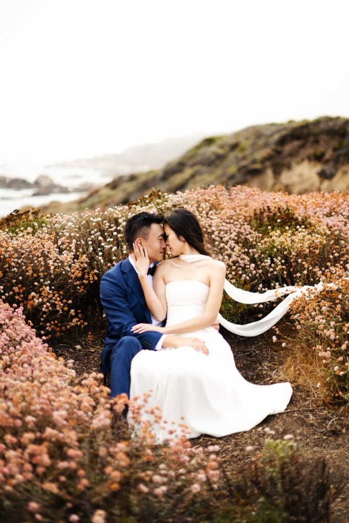 Bride and groom eloping on a cliff side in Big Sur California mid day during wild flower season.