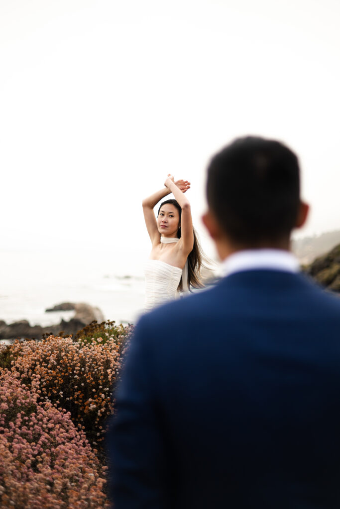 Bride and groom eloping on a cliff side in Big Sur California mid day during wild flower season.