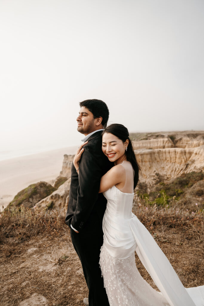 Bride and groom posing for photos at half moon bay