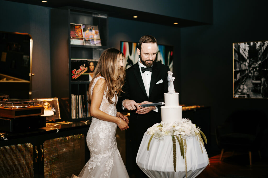 Bride and groom cutting cake with vintage cake topper
