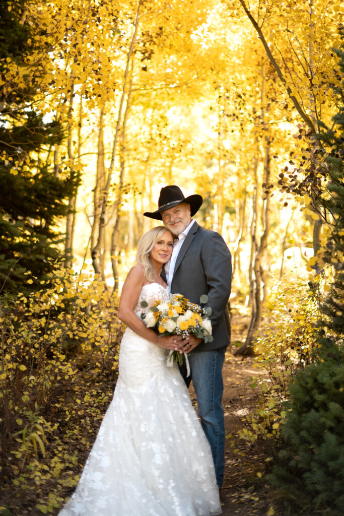 Bride and groom eloping in the mountains in western wedding attire. 