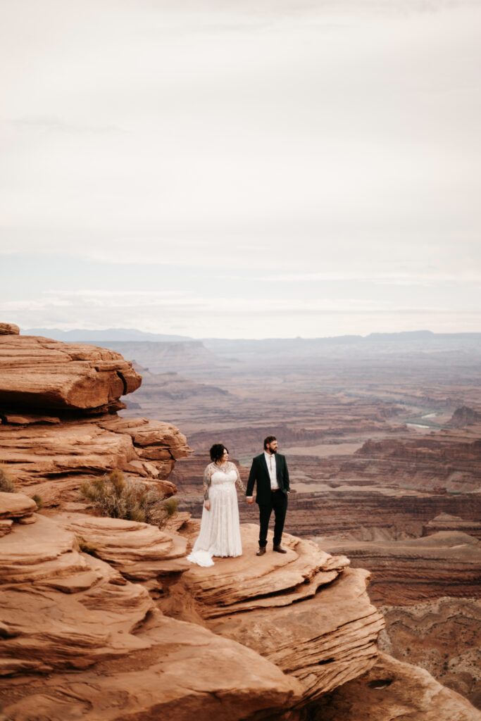 Bride and Groom standing on a cliff edge