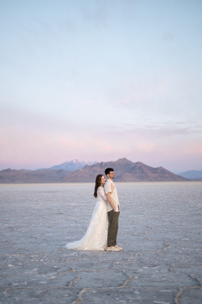 Sunrise bridal portraits at the Bonneville Salt Flats with soft pastel sky
