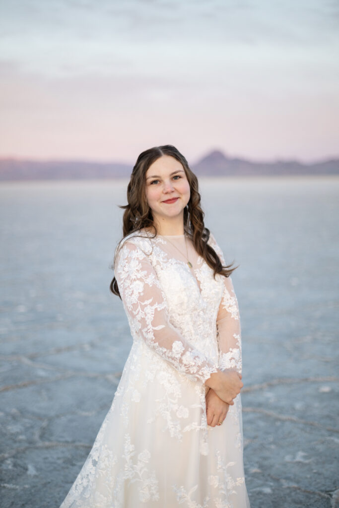 Sunrise bridal portraits at the Bonneville Salt Flats with soft pastel sky