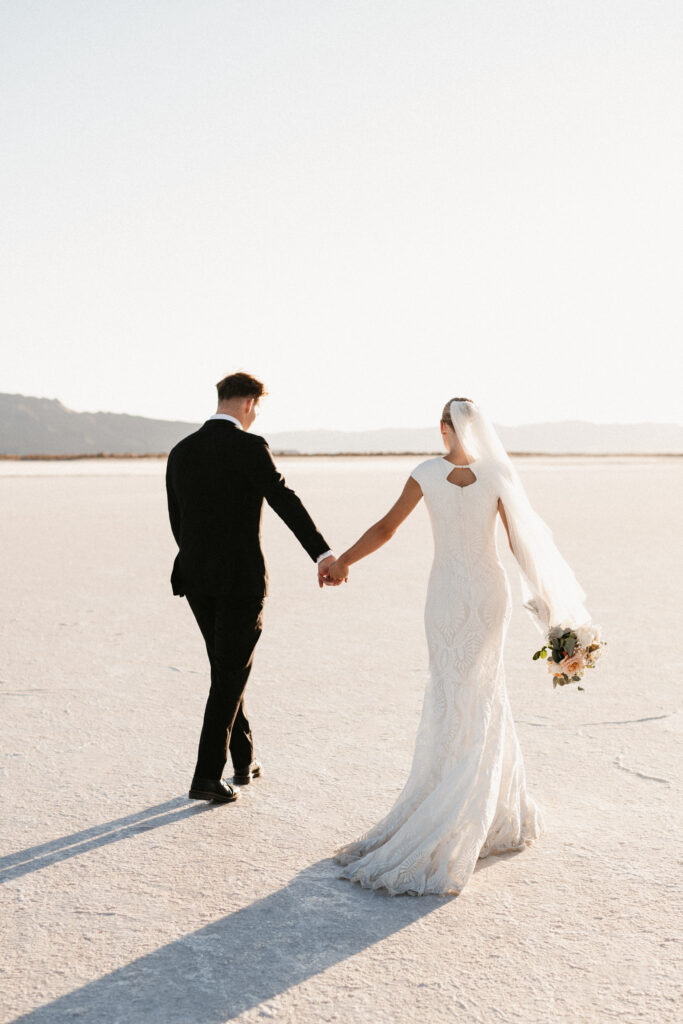 Bride and groom eloping at Bonneville Salt Flats with mirror reflection after rain