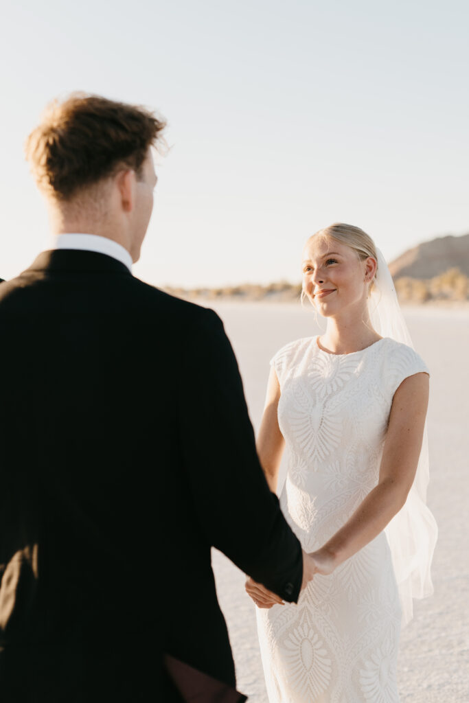 Bride in flowing dress at Bonneville Salt Flats elopement with wind and dramatic sky