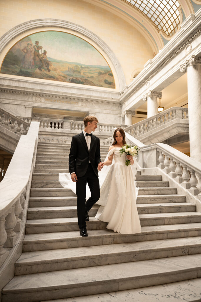 Bride and Groom walking down the steps at the Utah State Capitol Building in Salt Lake City, Utah
