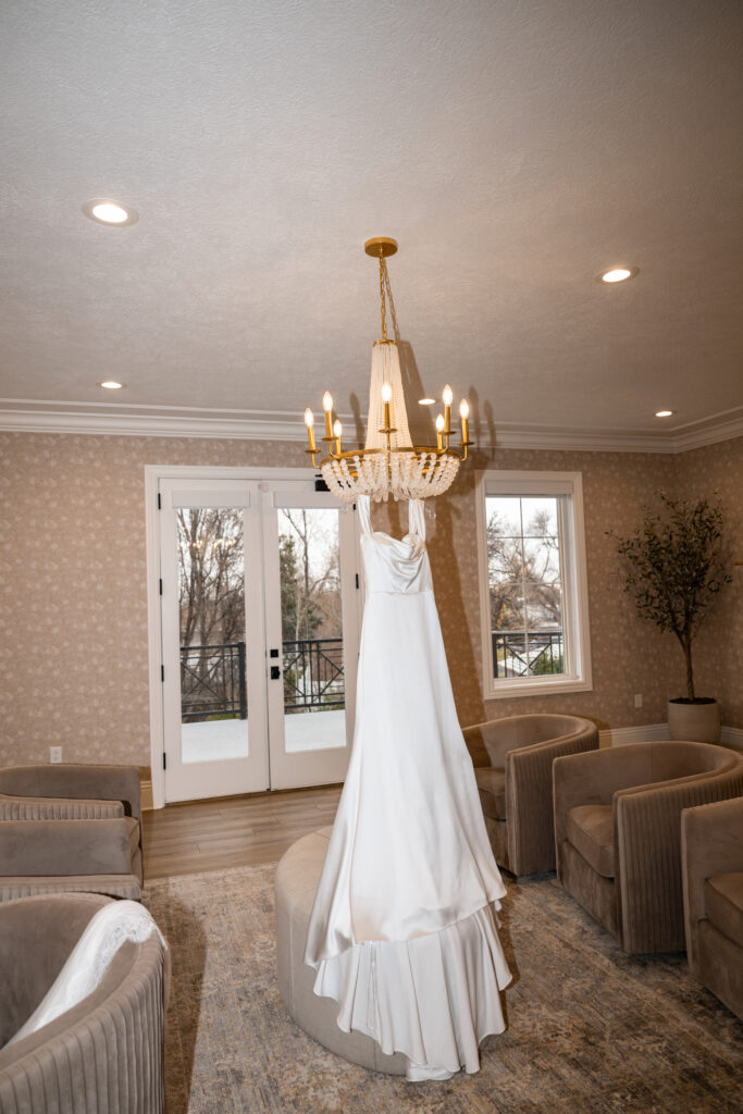 Brides dress hanging from chandelier 