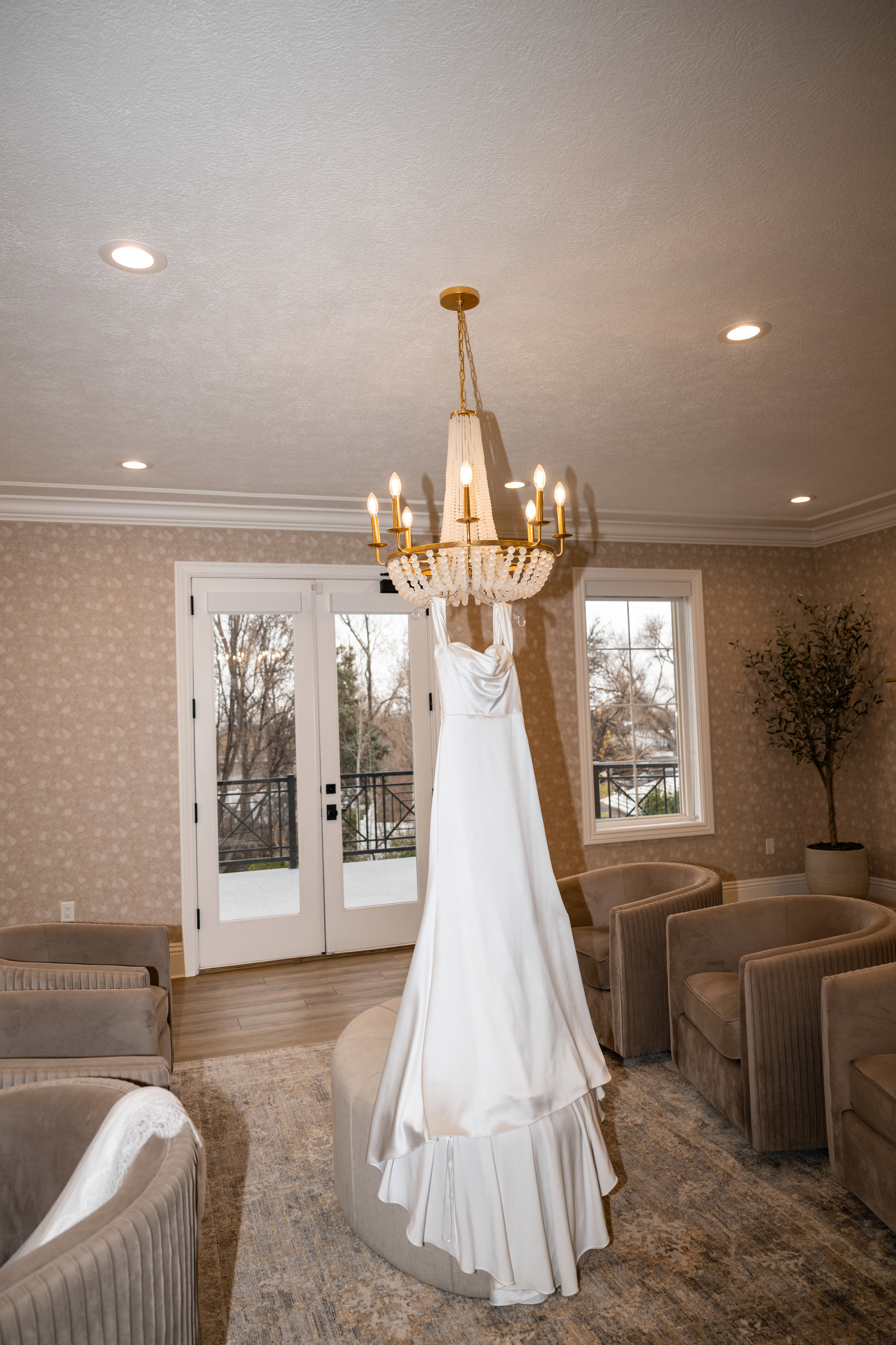Brides dress hanging from chandelier